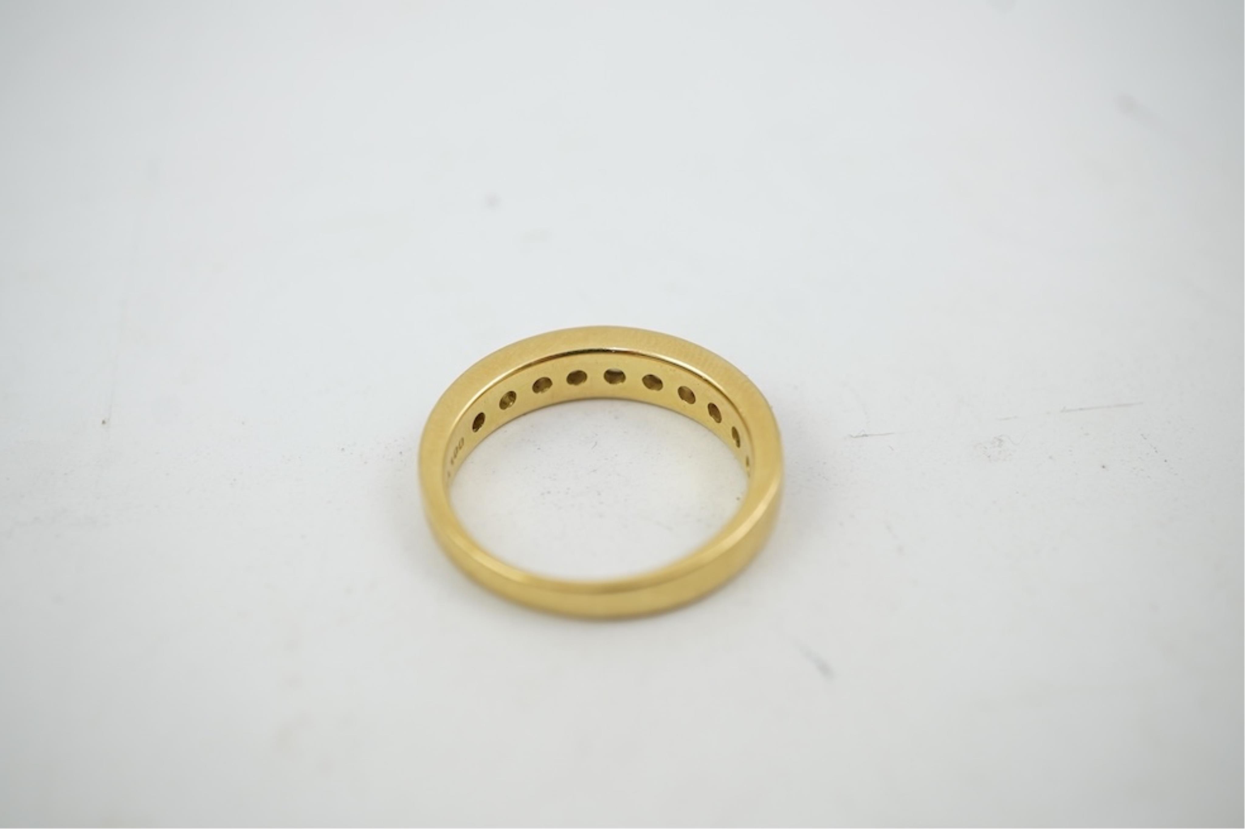 A modern 18ct gold and channel set graduated ten stone diamond set half eternity ring, size Q, gross weight 5.4 grams.
